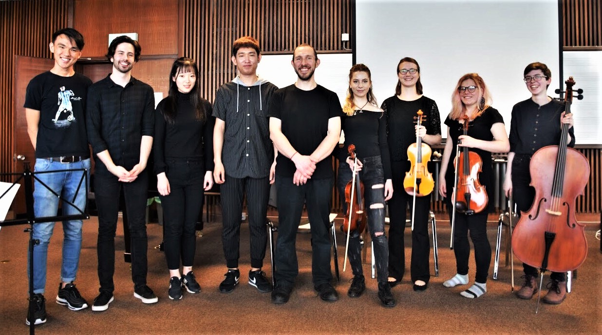 A group of musicians standing with their instruments in hand.